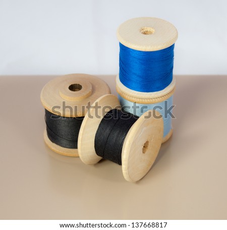 Four vintage wooden spools of thread.