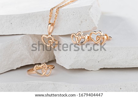 Jewellery set of hearts shape rose gold ring, pendant necklace and stud earrings on white background. Romantic  jewelry. Advertising still life product concept for Valentines Day