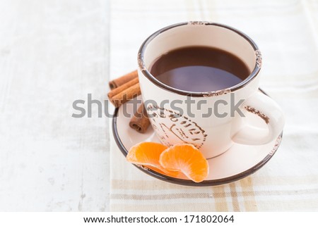 coffee with slices of mandarin and cinnamon