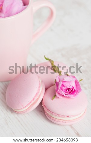 Gentle pink macaroons with rose on wood, pastel colored, selective focus