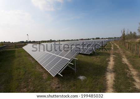 Ecology electric energy farm with solar panel battery in green field and modern solar panels in a beautiful green field