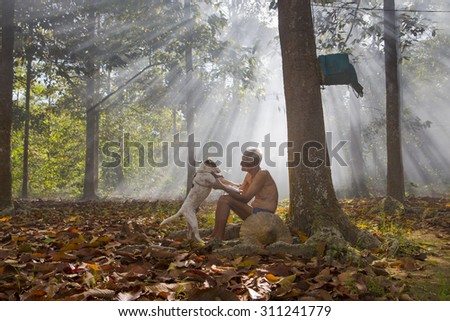 DAU TIENG, BINH DUONG, VIETNAM: November 24, 2013. A view man take care dog in ray of sunshine. DAU TIENG, BINH DUONG, VIETNAM: November 24, 2013