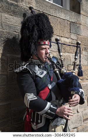 Edinburgh 08/06/2015: visiting Edinburgh people can see street artist that on the old streets of the town plays pipe with the typical vest of Sctland. They give the tight atmosphere of the town .