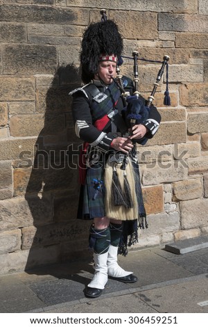 Edinburgh 08/06/2015: visiting Edinburgh people can see street artist that on the old streets of the town plays pipe with the typical vest of Sctland. They give the tight atmosphere of the town .