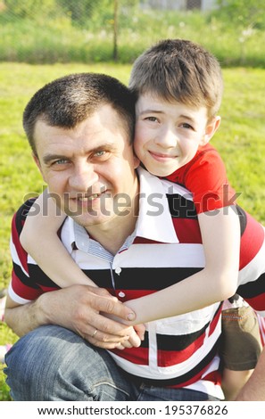 Happy dad with son. Happy father with his son on a background of grass.