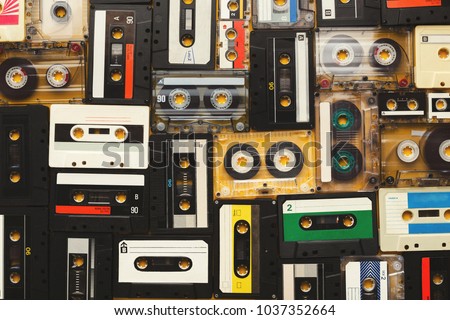 Retro audio cassette tapes on beige background. Top view on vintage media devices, copy space on labels, flat lay