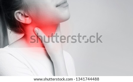 Sore thyroid. Woman suffering from touching her throat, gland control. Black and white photo with red accent Stok fotoğraf © 