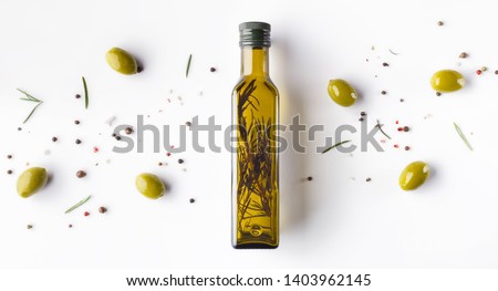Olive oil with herbs in bottle, scattered olives and rosemary on white background, top view. Food background concept ストックフォト © 