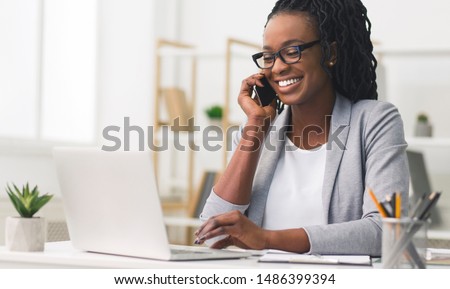 Similar – Image, Stock Photo Young afro American black man wearing a white sweatshirt and headphones seated on a blue wall looking to the side. Modern look