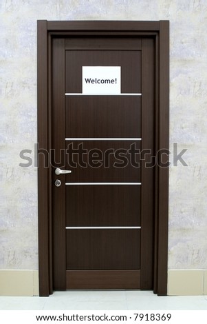 Modern door with a welcome notice on it