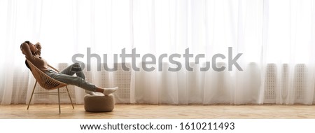 Wide Angle Shot Of Young Asian Girl Relaxing In Modern Wicker Chair Near Window, Enjoying Home Comfort, Extreme Long Banner, Panorama With Free Space