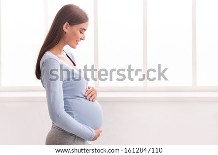 Similar – Image, Stock Photo Smiling pregnant woman touching belly on floor at home