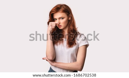 Disgust Concept. Girl Pinching Nose In Aversion Feeling Stinky Smell Standing On White Studio Background. Panorama Imagine de stoc © 