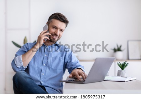 Similar – Image, Stock Photo Man talking on smartphone while browsing laptop