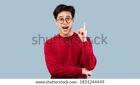 Wow, Eureka. Portrait of emotional asian student having great idea, finding inspiration or solution to problem. Excited amazed guy in glasses with open mouth pointing finger up over studio background