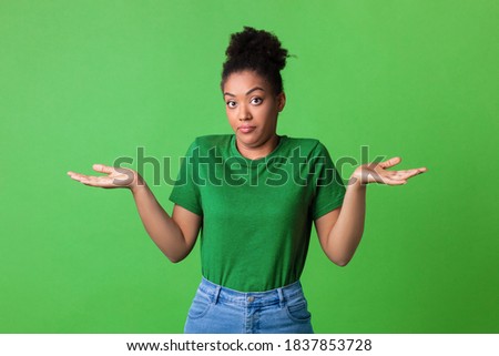 Who Knows. Portrait of Funny Young Black Woman Shrugging Shoulders Looking At Camera Posing Over Green Background. Studio Shot. Puzzled lady is clueless. I'm sorry, exuse me, can't decide Photo stock © 