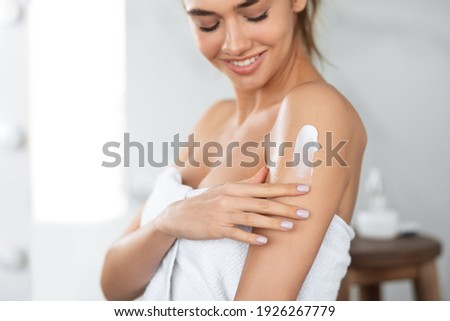 Body Care. Woman Applying Moisturizing Lotion Or Cream On Shoulders Caring For Skin At Home, Standing In Bathroom. Skincare And Pampering, Beauty Routine Concept. Cropped, Selective Focus