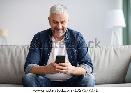 Similar – Image, Stock Photo Man using his smartphone sitting on a ledge outside