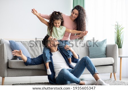 Happy Family Leisure. Cheerful arabic mom, dad and daughter having fun together