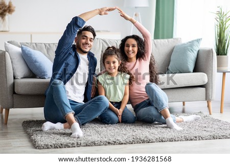 Family Protection. Mom And Dad Making Roof Of Hands Above Their Daughter