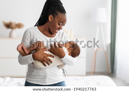 Similar – Image, Stock Photo Mom breastfeeding baby and writing in copybook in house