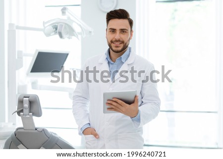 Similar – Image, Stock Photo Young bearded male dentist drilling tooth to female patient