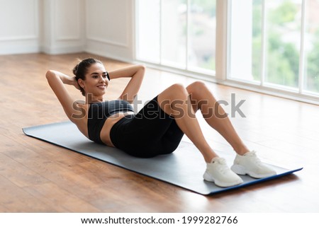 Healthcare, Physical Activity And Sports. Fit Young Lady Exercising At Fitness Club Studio Or Living Room Doing Sit-Ups Crunches Exercise Indoors Lying On Yoga Mat, Training Abdominal Muscles Сток-фото © 