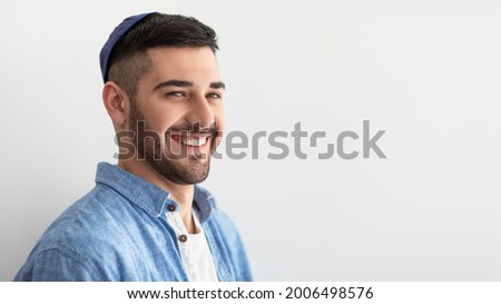 Closeup headshot portrait of casual cheerful jewish guy in yarmulke standing at studio, looking and posing at camera with a smile isolated on white studio background, free copy space, panoramic banner Foto stock © 