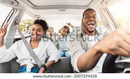 Summer Road Trip. Happy Black Family Of Three Riding Car And Singing Having Fun Traveling By Automobile. Parents And Daughter Enjoying Auto Ride Together On Weekend. Panorama, Selective Focus