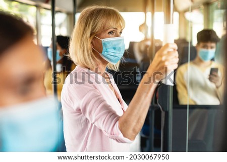 Similar – Image, Stock Photo Serious passengers in protective masks during their train trip