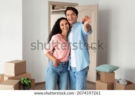 House Ownership. Portrait Of Happy Young Couple Holding Showing Key Standing In New Flat, Cheerful Guy And Lady Posing Hugging After Moving In Own Apartment. Insurance, Real Estate, Mortgage Concept Stock foto © 