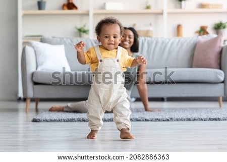 Similar – Image, Stock Photo Adorable little baby boy in feeding chair being spoon fed by his mother