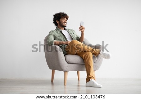 Similar – Image, Stock Photo Man using a mobile phone sitting on the grass with a sports bag