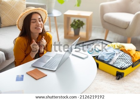 Overjoyed young woman booking hot tour online, excited over huge sale in tourist agency, using laptop to book hotel or buy plane tickets on discount from home, free space. Abroad travel concept Сток-фото © 