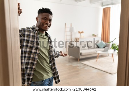 Welcome To My House. Cheerful Black Man Opening Door And Gesturing Inviting To Come In And Showing His Living Room Smiling To Camera Standing At Home. Real Estate Ownership And Hospitality ストックフォト © 