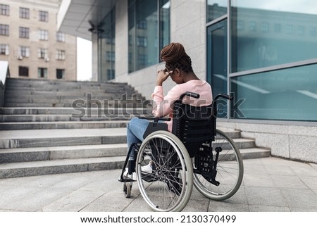 Unhappy young black woman suffering from lack of wheelchair friendly facilities, cannot get home without ramp, copy space. Inaccessible city environment for people with special needs concept Foto d'archivio © 