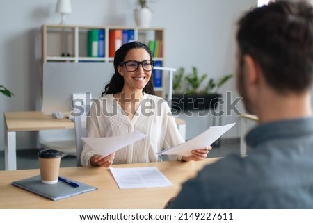 Searching for job concept. Happy human resources manager speaking to employment applicant on work interview, holding CV at office. Personnel manager talking to vacancy candidate Foto stock © 
