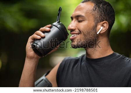 Similar – Image, Stock Photo Man with earbuds using tablet and laptop at table