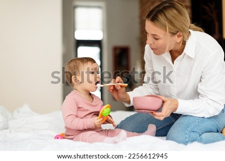 Similar – Image, Stock Photo Mom feeds her little son sitting on a chair in the kitchen