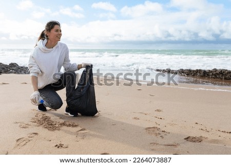 Similar – Image, Stock Photo Young woman cleaning beach area and showing plastic bottle lids in hand