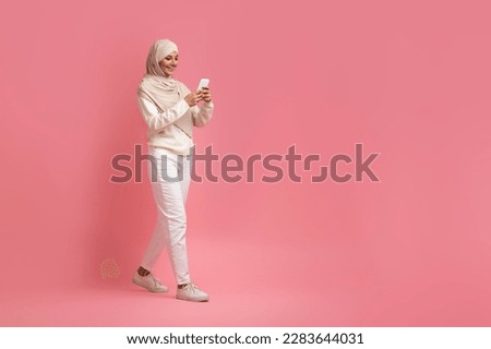 Similar – Image, Stock Photo Young Arab woman walking in the street using her smartphone