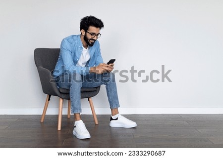 Similar – Image, Stock Photo Man using a mobile phone sitting on the grass with a sports bag