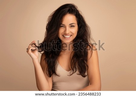 Similar – Image, Stock Photo Gorgeous dark-haired young woman stands with big eyes and demanding look in an old willow tree with fine shoulders