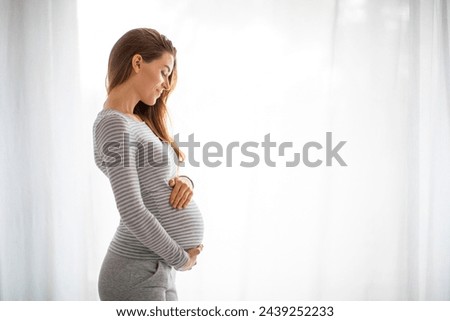 Similar – Image, Stock Photo Smiling pregnant woman touching belly on floor at home