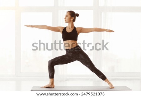 Similar – Image, Stock Photo Calm woman in Warrior pose on yoga mat