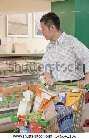 Man standing and looking at the Deli counter, Beijing
