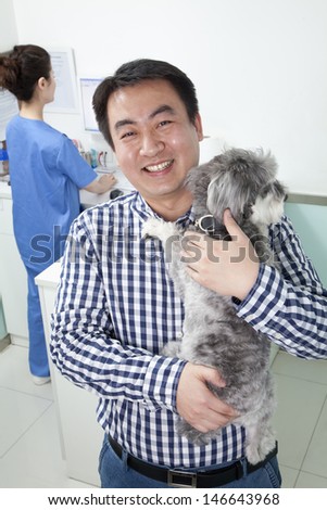 Man with pet dog in veterinarian's office