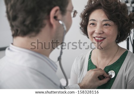 Doctor checking heartbeat of a patient with a stethoscope