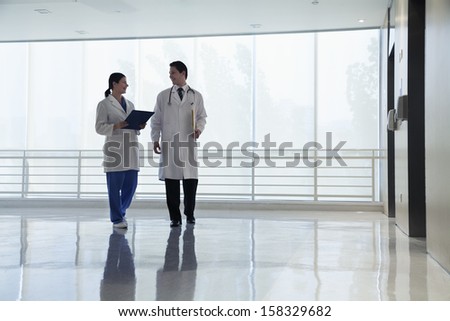 Two doctors walking and smiling in the hospital