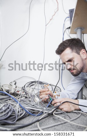 Frustrated man sorting computer cables